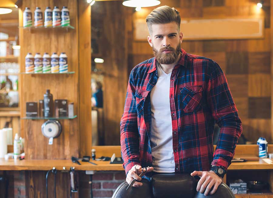Young man in a barbershop confident look done with hairstyle